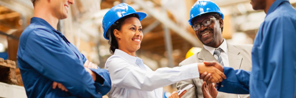 Warehouse manager shaking hands with warehouse worker